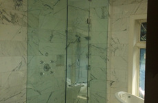 Frameless steam shower door with fixed transom