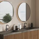Round mirrors above a double vanity in a modern bathroom.