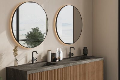 Round mirrors above a double vanity in a modern bathroom.