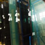 Large custom glass panels stored in a glass fabrication facility.