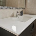 A glass countertop in the bathroom, both aesthetically pleasing and easy to maintain, helps create a clean environment with an elegant feel.