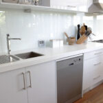 An appealing modern kitchen with a glass backsplash.