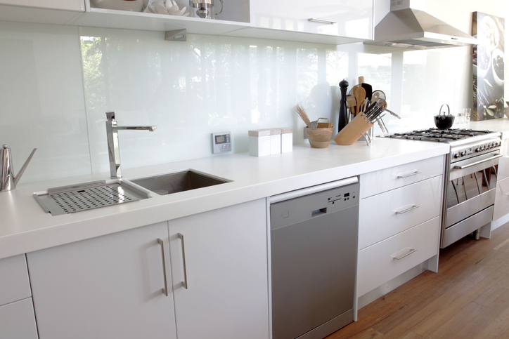 An appealing modern kitchen with a glass backsplash.