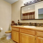 Acrylic vs glass mirror comparison shown in a bathroom vanity with framed mirror reflecting clarity and durability differences.