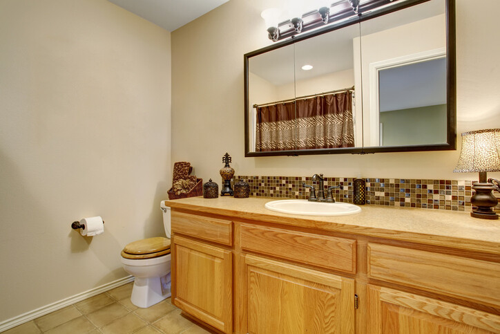 Acrylic vs glass mirror comparison shown in a bathroom vanity with framed mirror reflecting clarity and durability differences.