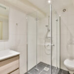 How to get rid of soap scum on glass shower doors using a clean modern bathroom with clear glass shower enclosure.