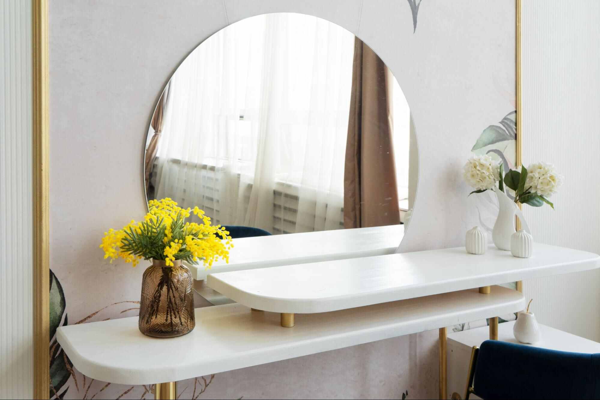 Frameless wall mirror mounted above a sleek vanity table, adding brightness and visual space to a minimalist home interior.