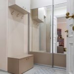 Two way mirror glass closet doors in a modern home entryway with built-in storage bench.