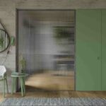 Architectural glass with a reeded texture used in an interior door to provide privacy while allowing natural light through.